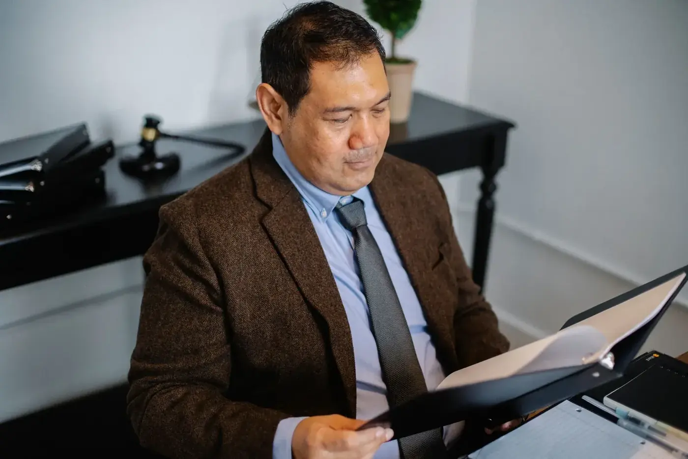A bilingual accountant going through a client file at his desk