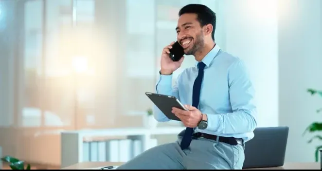 An account manager taking a client call at his desk